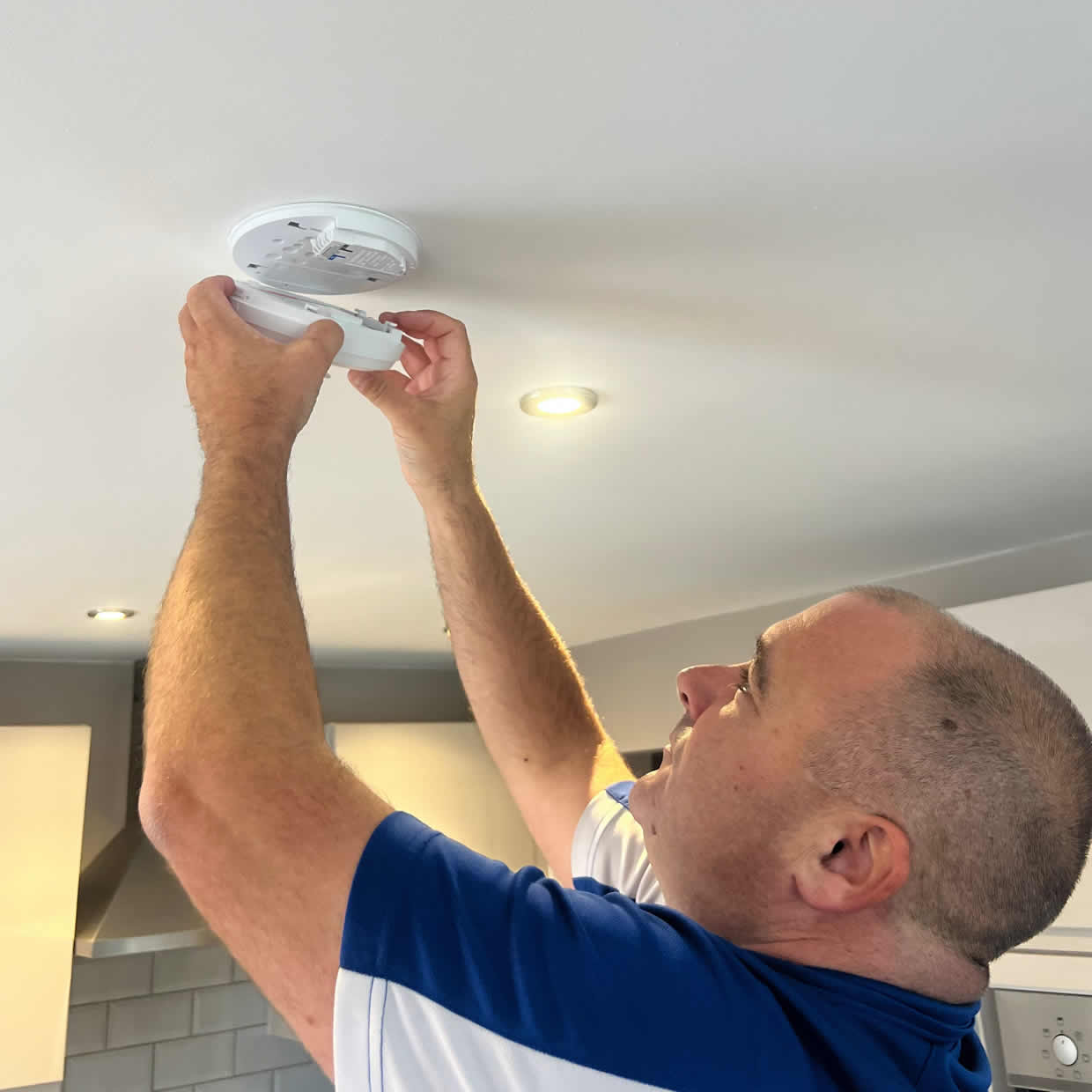 Smoke alarm being installed on a ceiling in Bristol